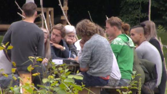 De bewoners uit Utopia 2 houden een financiële vergadering met een adviseur