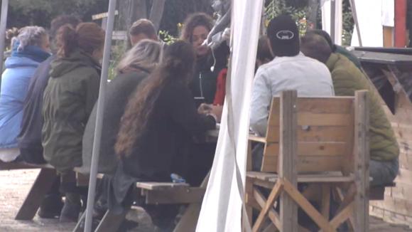 De bewoners uit Utopia 2 houden een vergadering over het groepsgevoel